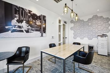 A modern dining room with a large table and chairs. at Link Apartments® 4th Street, Winston-Salem, North Carolina