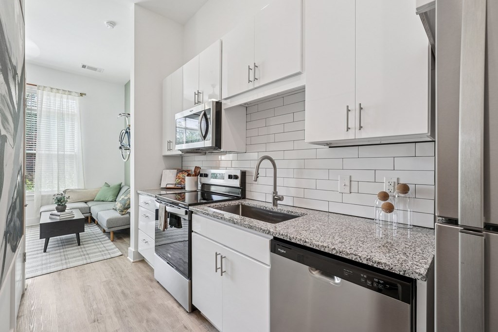 A modern kitchen with stainless steel appliances and white cabinets at Link Apartments® CYKEL Apartments, Charlotte, NC