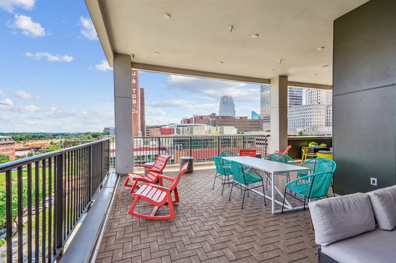 a balcony with a table and chairs and a view of the city at Link Apartments Innovation Quarter, Winston Salem, NC, 27101