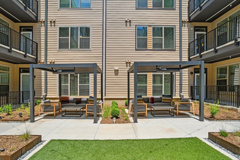 a patio with furniture in front of a building at Link Apartments® NoDa 36th, Charlotte