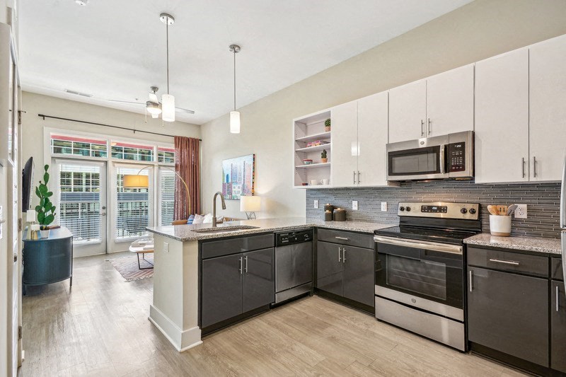 a large kitchen with stainless steel appliances and white cabinets at Link Apartments Innovation Quarter, Winston Salem