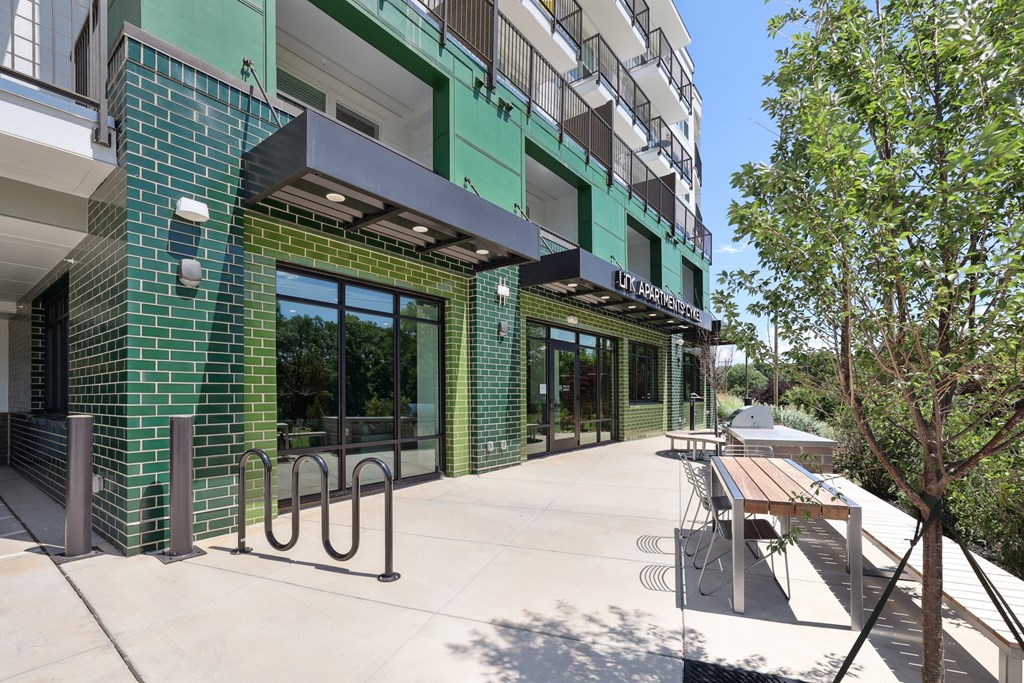 A modern building with a green and white exterior and a tree in front at Link Apartments® CYKEL Apartments, Charlotte