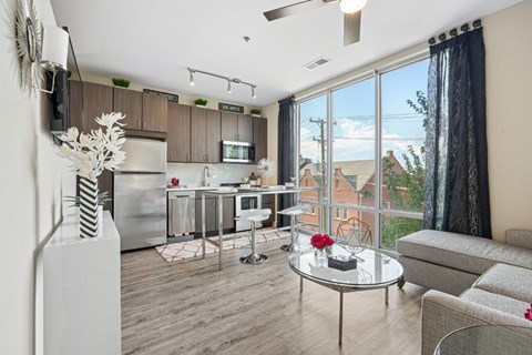 A modern kitchen with a glass table and a couch.