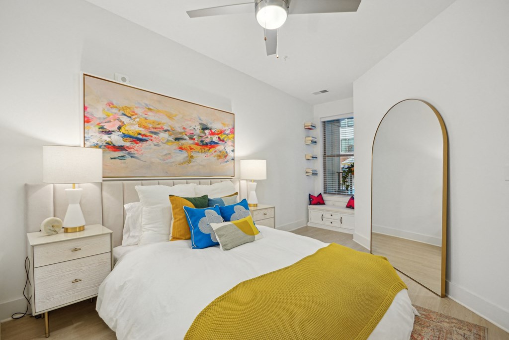 a bedroom with a white bed and a yellow blanket at Link Apartments® Calyx, Chapel Hill, 27517