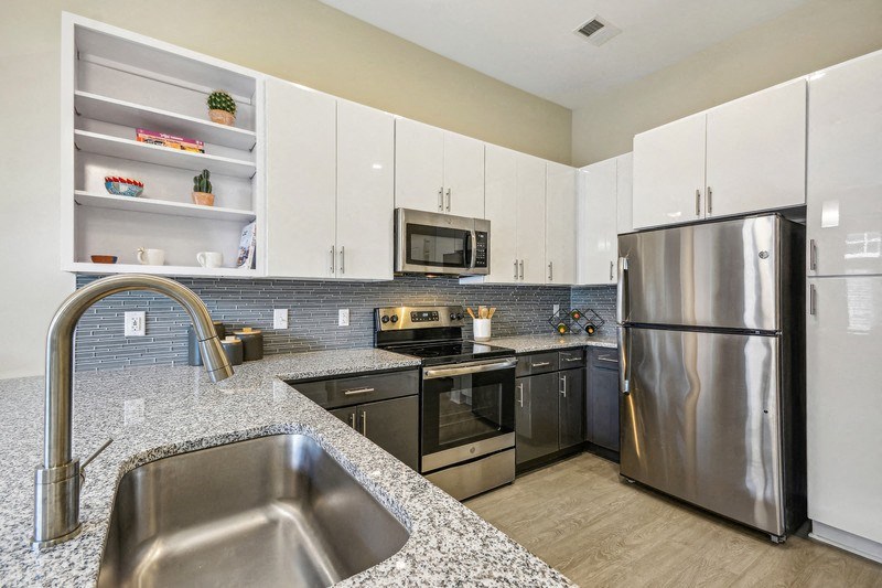 a modern kitchen with stainless steel appliances and granite counter tops at Link Apartments Innovation Quarter, Winston Salem, 27101