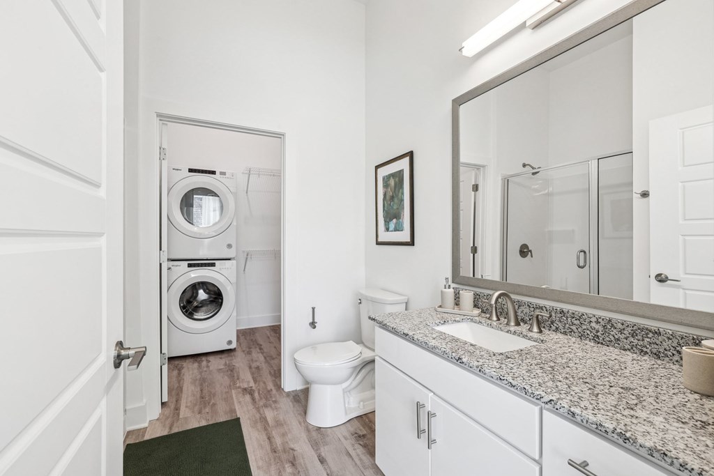 A bathroom with a washer and dryer in the doorway at Link Apartments® CYKEL Apartments, North Carolina