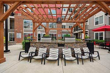 a patio with a bar and chairs in front of an apartment building