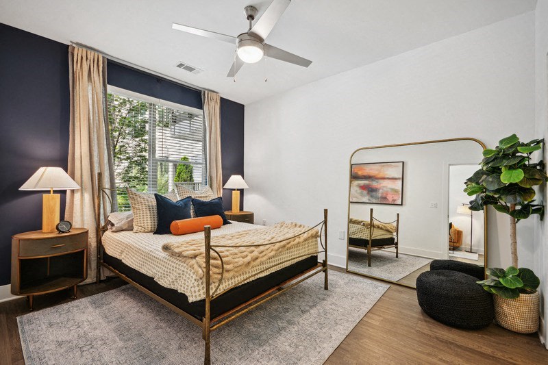 a bedroom with a bed in a room with a large window at Link Apartments® 4th Street, Winston-Salem, 27101