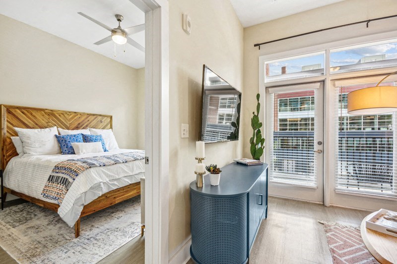 a bedroom with a bed and a door to a balcony at Link Apartments Innovation Quarter, North Carolina, 27101