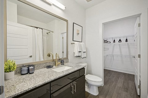 a bathroom with a mirror and a toilet and a shower at Link Apartments® 4th Street, Winston-Salem