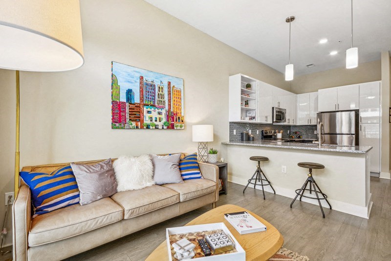 a living room with a couch and a kitchen at Link Apartments Innovation Quarter, Winston Salem, NC