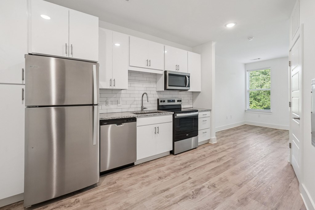 A modern kitchen with stainless steel appliances and white cabinets at Link Apartments® CYKEL Apartments, Charlotte, NC