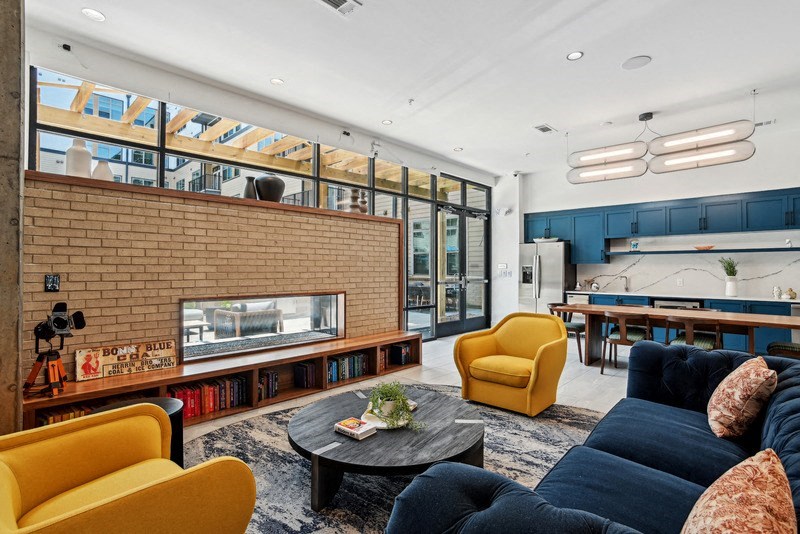 a living room with a fireplace and a table and chairs at Link Apartments® NoDa 36th, Charlotte, North Carolina