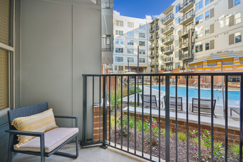 the view of a pool from a balcony with a chair at Link Apartments® Calyx, Chapel Hill