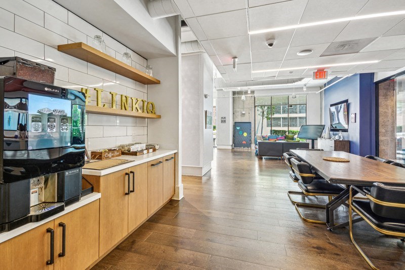 a dining room with a table and chairs and a coffee machine at Link Apartments Innovation Quarter, Winston Salem, 27101