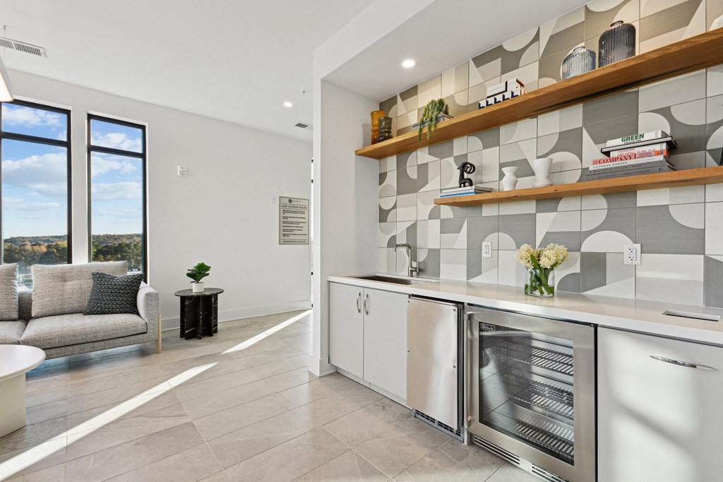 a kitchen with white cabinets and a large window at Link Apartments® Calyx, Chapel Hill, NC 27517