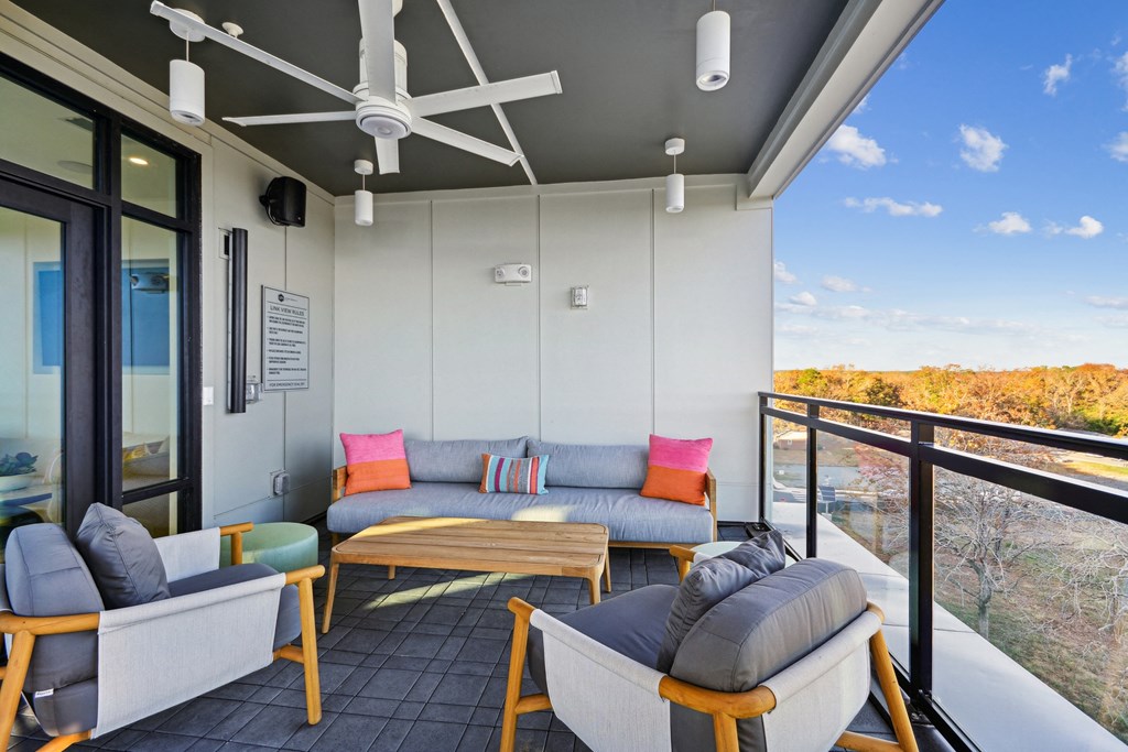 a living room with couches and chairs on a balcony at Link Apartments® Calyx, Chapel Hill North Carolina