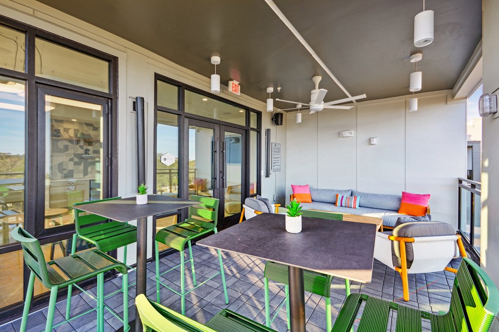 a patio with tables and chairs and sliding glass doors at Link Apartments® Calyx, Chapel Hill, NC 27517