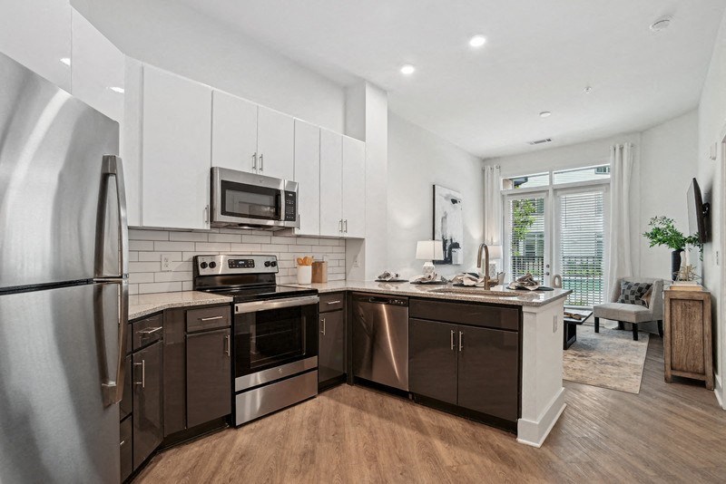 a large kitchen with stainless steel appliances and white cabinets at Link Apartments® NoDa 36th, Charlotte, North Carolina