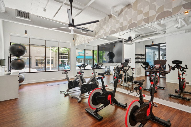 the gym has plenty of exercise bikes and other fitness equipment at Link Apartments® 4th Street, Winston-Salem