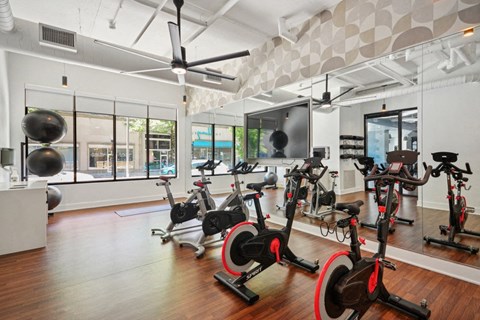 the gym has plenty of exercise bikes and other fitness equipment at Link Apartments® 4th Street, Winston-Salem