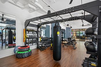 A gym with a punching bag, weights, and exercise equipment. at Link Apartments® 4th Street, Winston-Salem, North Carolina