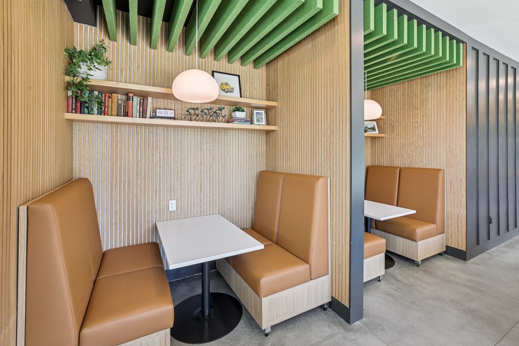 A modern dining area with tan leather chairs and a wooden table at Link Apartments® CYKEL Apartments, Charlotte, North Carolina