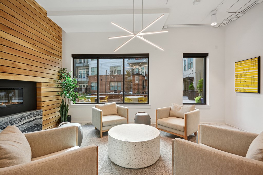 a living room with couches and chairs and a fireplace at Link Apartments® Calyx, Chapel Hill, NC