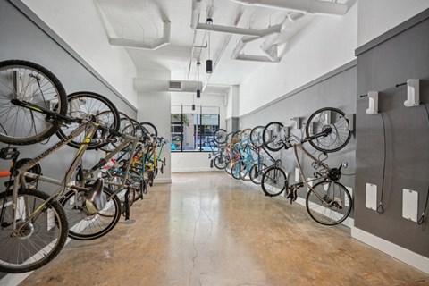 a row of bikes hanging on a wall in a room at Link Apartments® 4th Street, Winston-Salem, NC, 27101