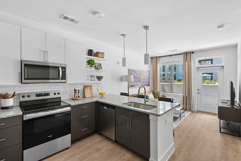 A modern kitchen with a black stove and black and white cabinets.