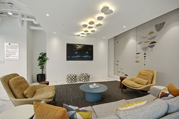 a living room with couches chairs and a table at Link Apartments® Calyx, North Carolina