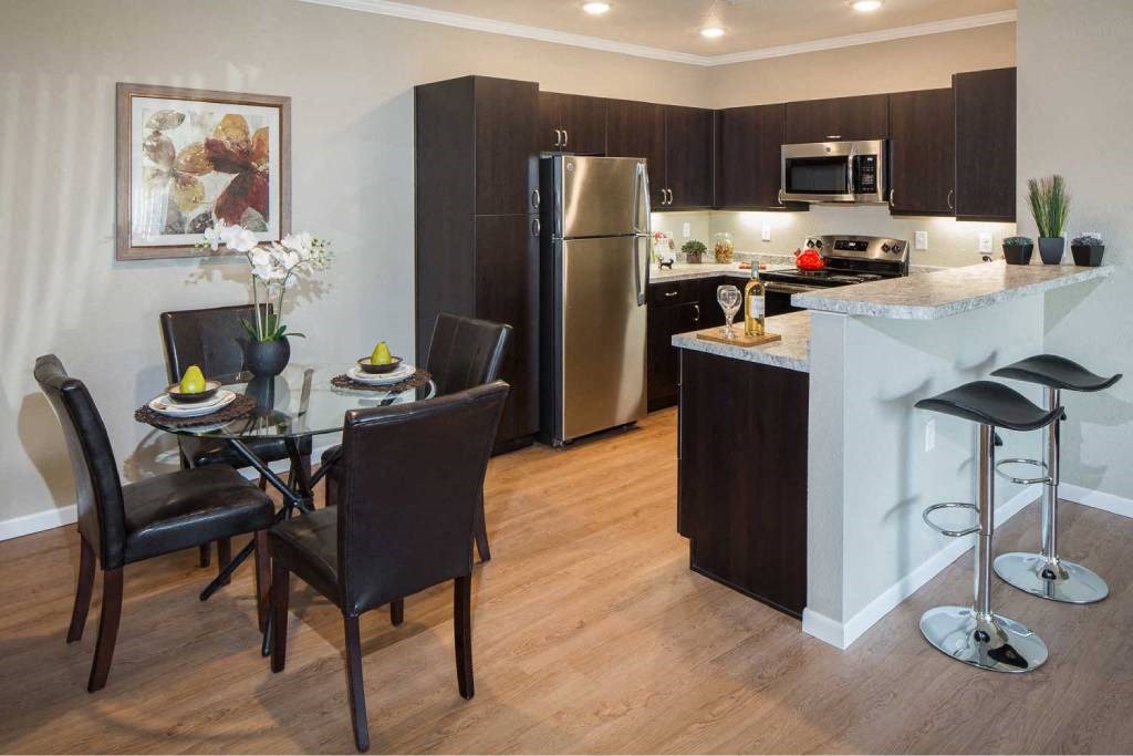 a kitchen and dining area with a stainless steel refrigerator