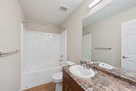A bathroom with a marble countertop and a walk-in shower.