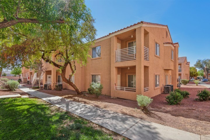 A row of houses with a tree in front of the first one.