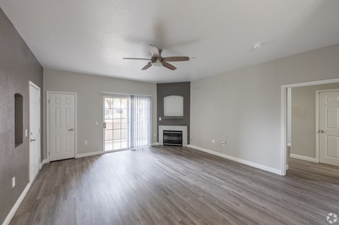 A spacious room with a ceiling fan and wooden flooring. at Cheyenne Villas, North Las Vegas, NV