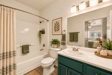 A bathroom with a white toilet, a white sink, and a white bathtub with a shower curtain.