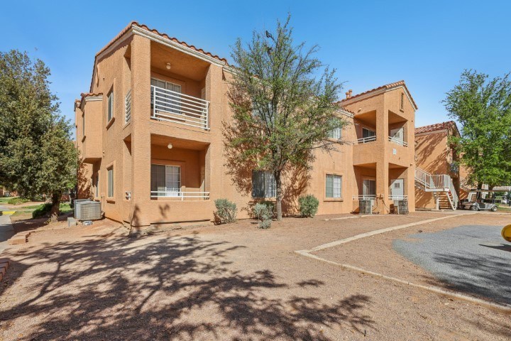 A building with a red roof and a parking lot in front.