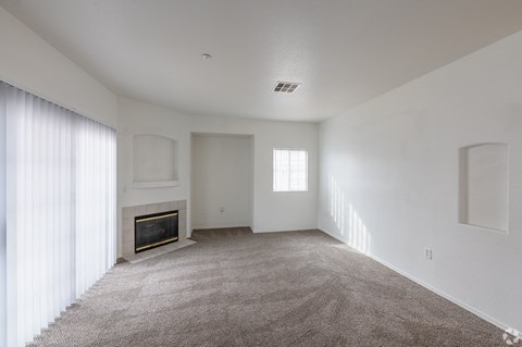 A living room with a fireplace and carpeted floor.