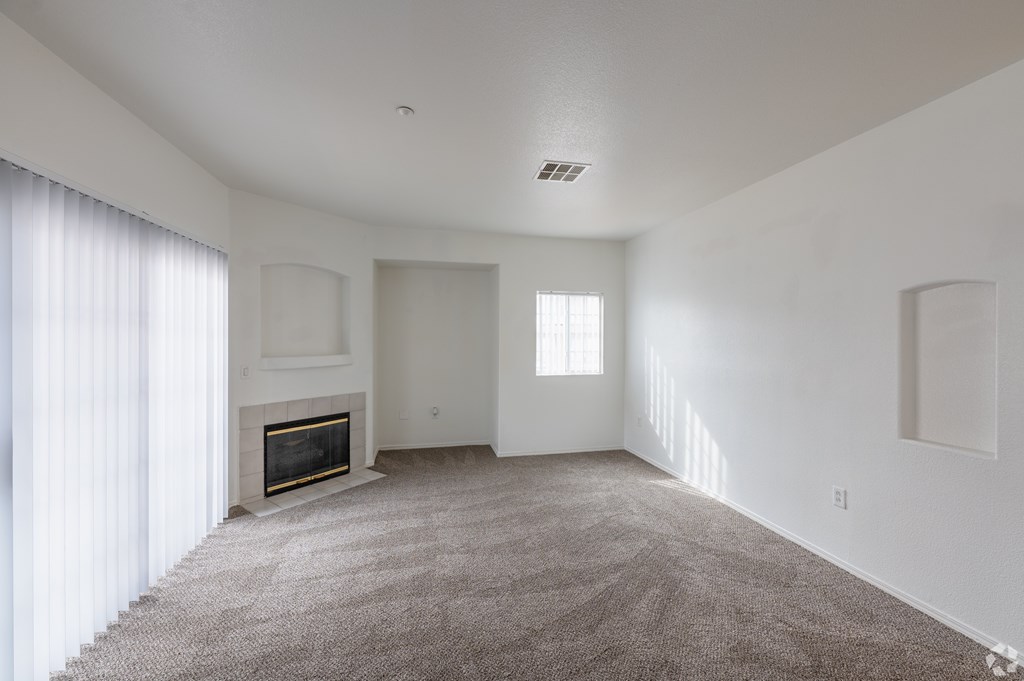 A living room with a fireplace and carpeted floor.