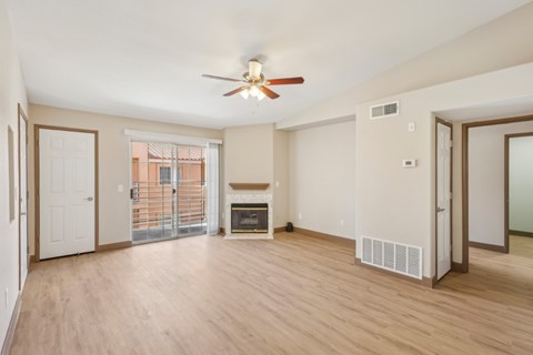 A spacious living room with a fireplace and sliding glass doors.