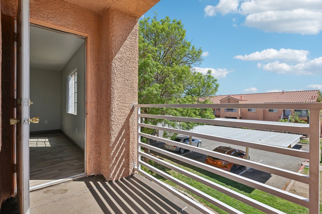 A view from a balcony looking out at a parking lot.
