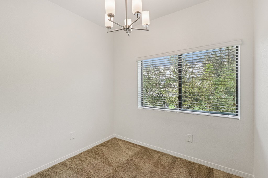 A room with a window covered by horizontal blinds.