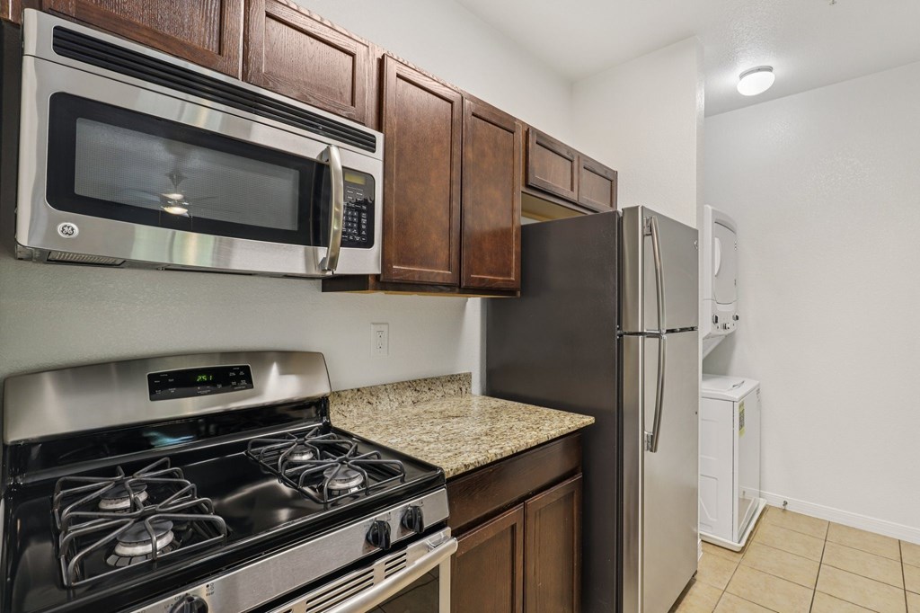 A kitchen with a stove, microwave, and refrigerator.
