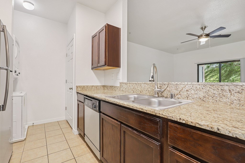 A kitchen with a marble countertop and a ceiling fan.