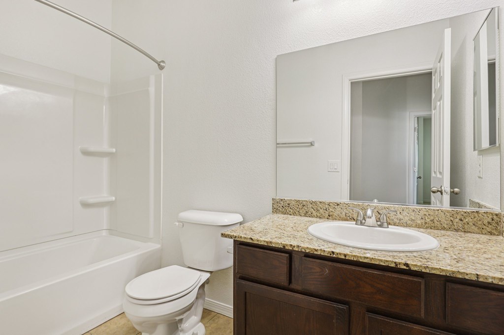 A white toilet sits next to a sink in a bathroom.