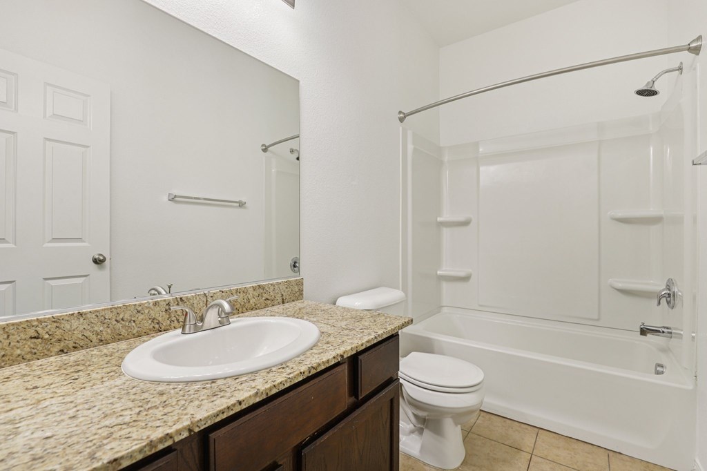 A bathroom with a sink, toilet, and bathtub.