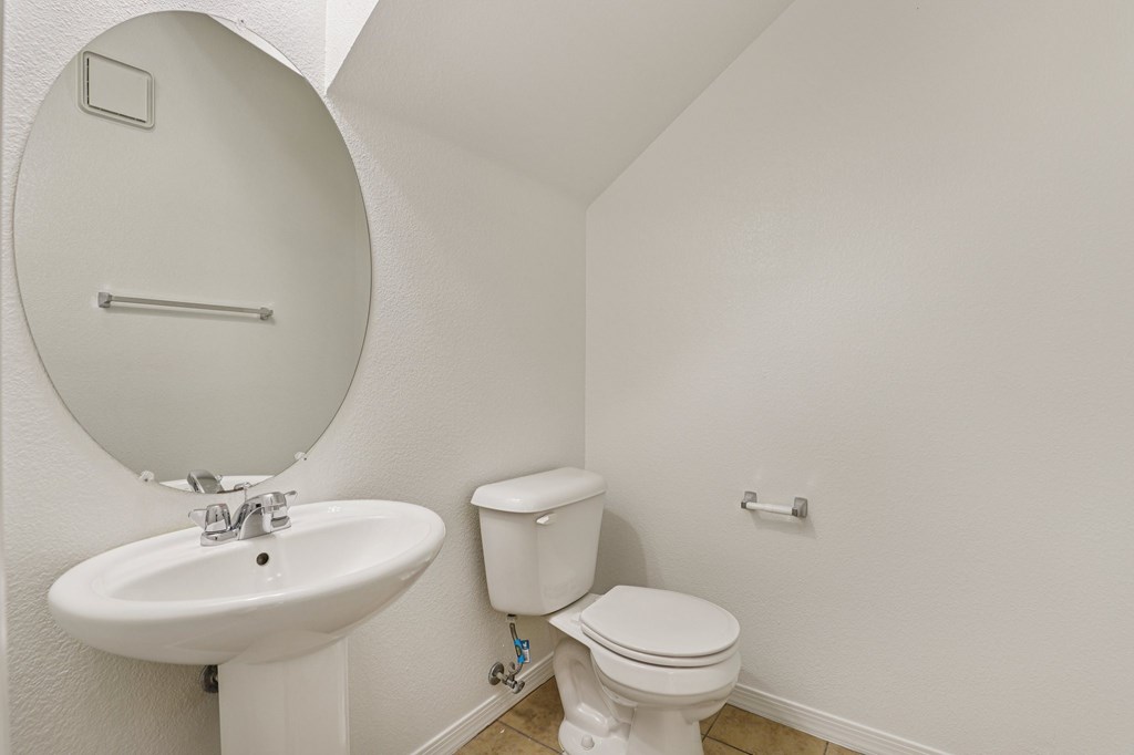 A white toilet sits next to a sink in a small bathroom.