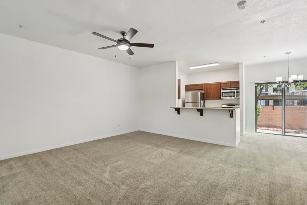 A room with a ceiling fan and carpeted floor.