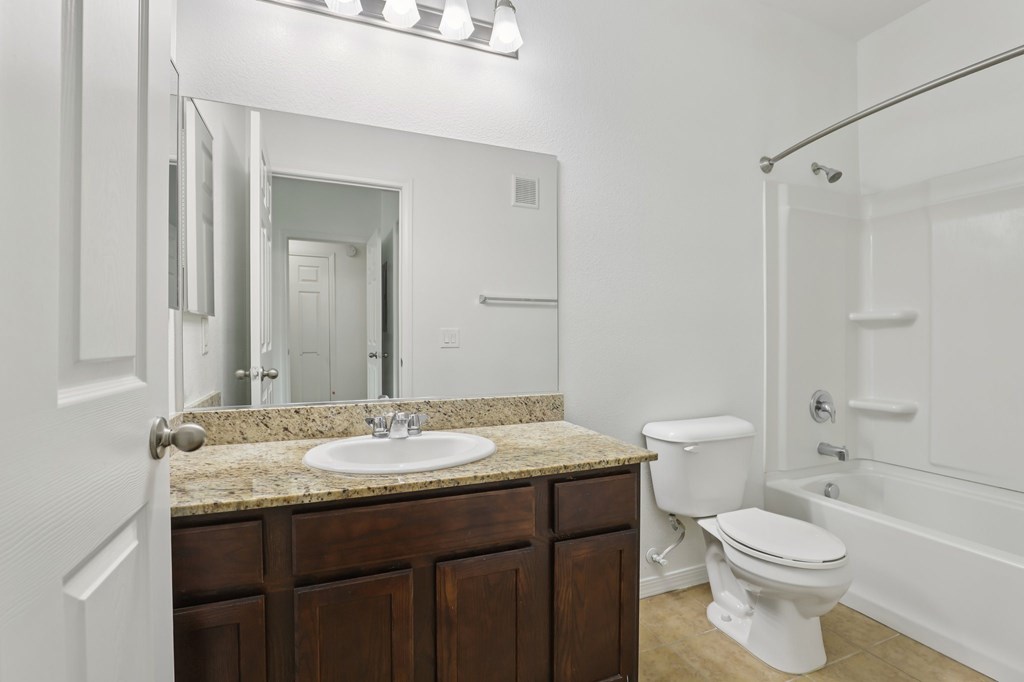 A white toilet sits next to a sink in a bathroom.