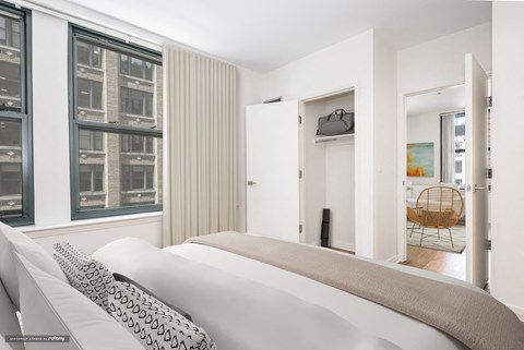 a bedroom with a bed and a large window